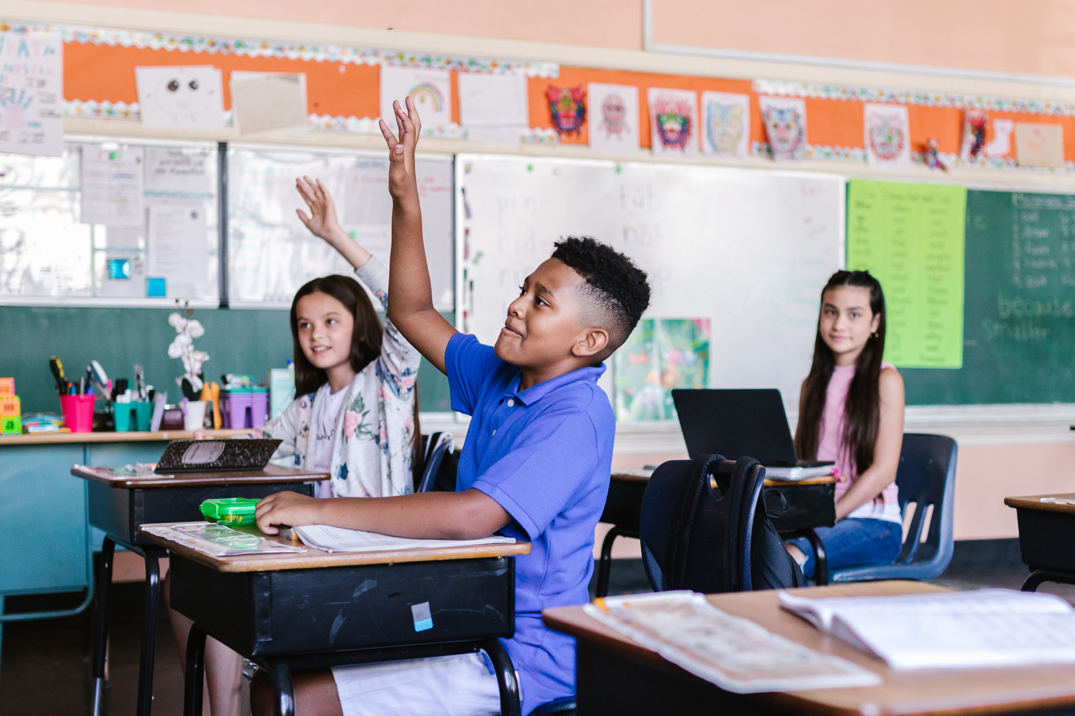 Student raising his hand in a classroom