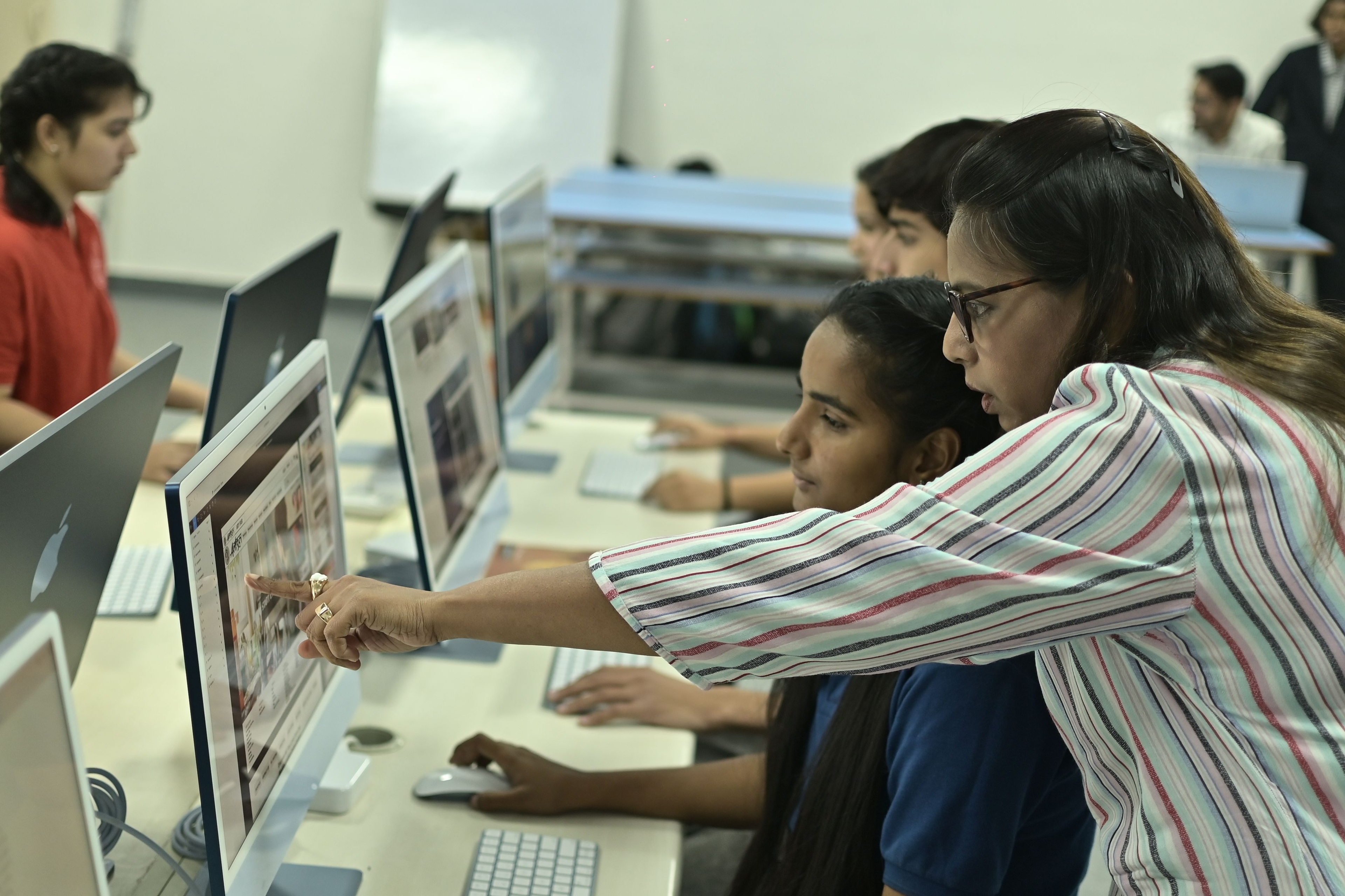 Students working with a mentor in a computer lab